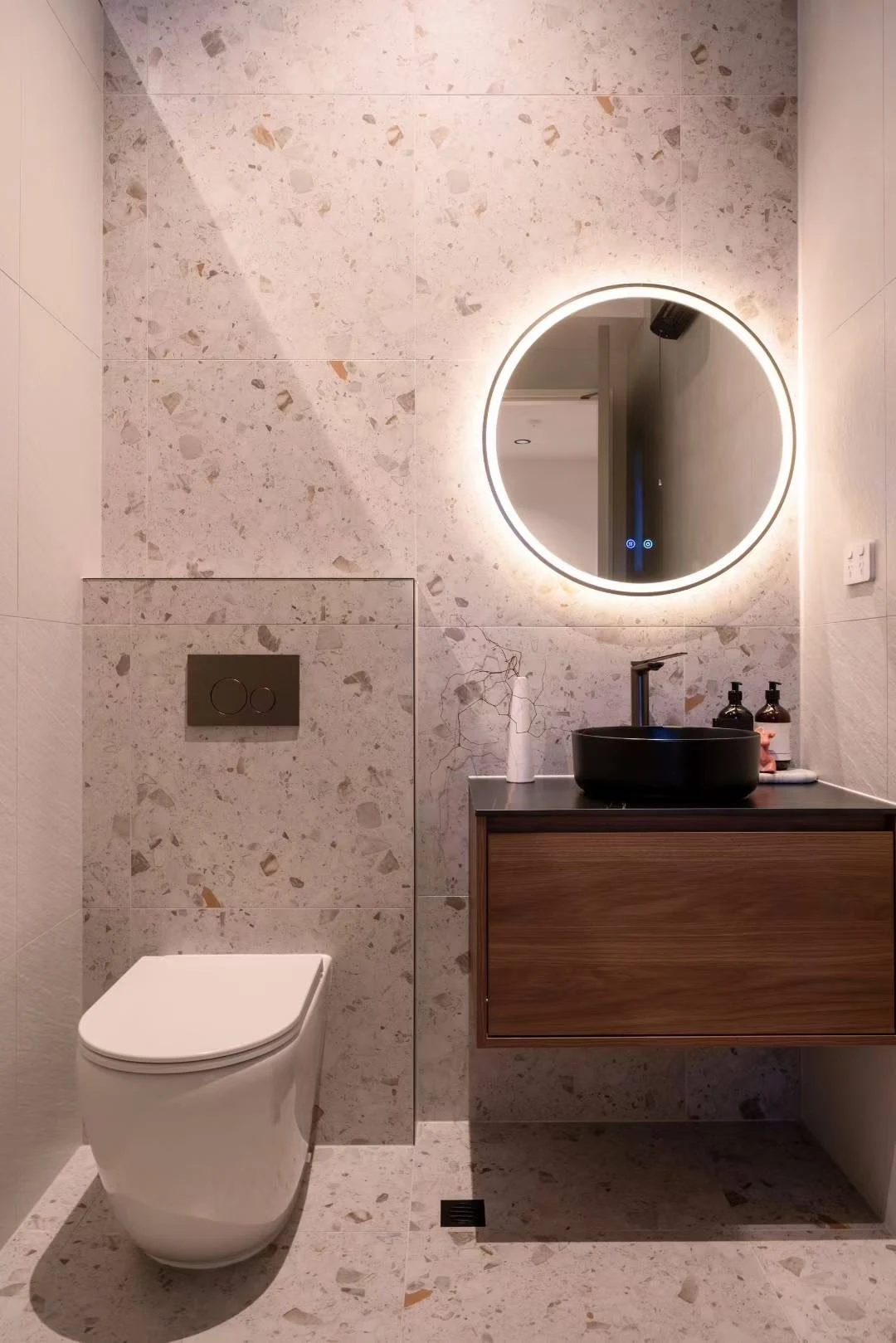 A terrazzo-look feature brings mineral colour to the powder room.